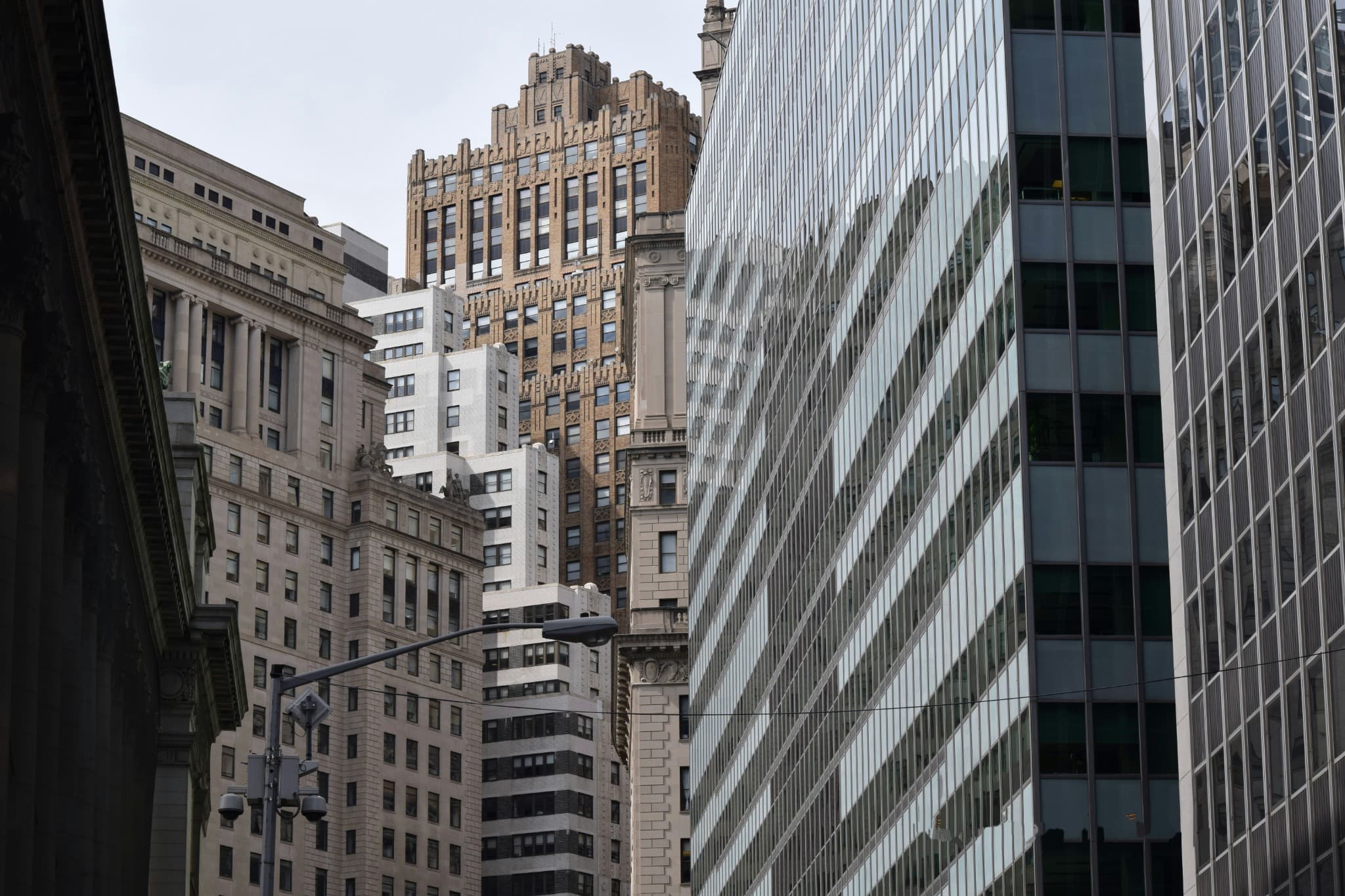 City street framed by stone and glass high-rise buildings